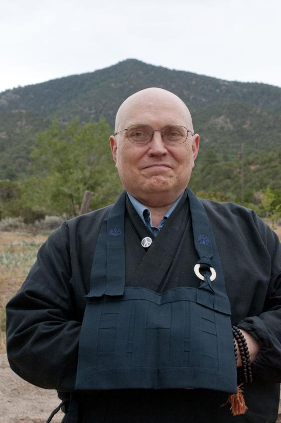 Zen priest Teigen Leighton in front of a green mountain